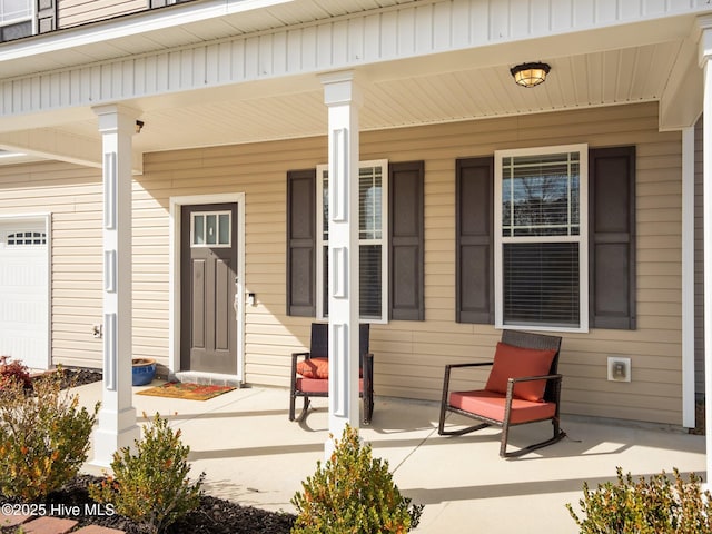 doorway to property featuring a porch and a garage