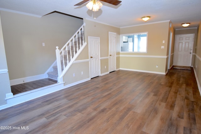 unfurnished living room featuring crown molding, stairway, wood finished floors, and baseboards