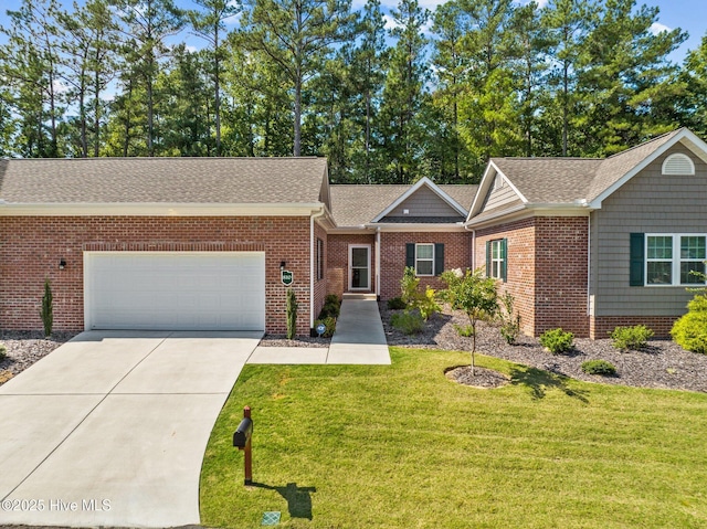 view of front of home with a front yard, roof with shingles, an attached garage, concrete driveway, and brick siding