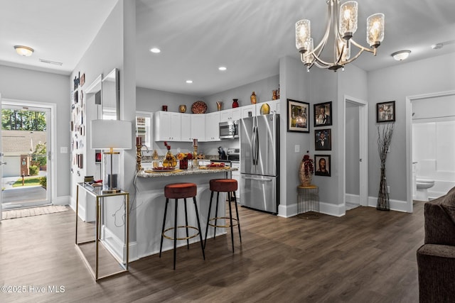 kitchen featuring an inviting chandelier, a wealth of natural light, a peninsula, and appliances with stainless steel finishes