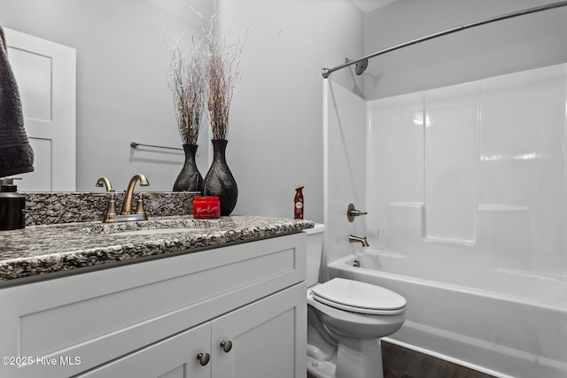 full bath with tub / shower combination, toilet, wood finished floors, and vanity