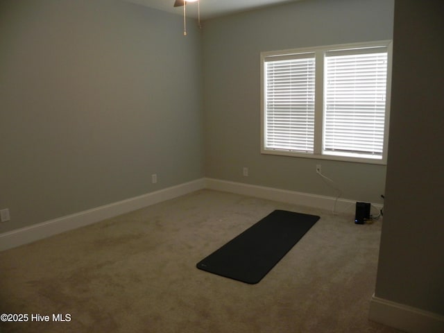 empty room with a ceiling fan, baseboards, and carpet floors