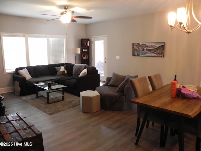 living area featuring ceiling fan with notable chandelier and wood finished floors