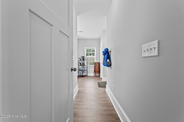 hallway with baseboards and wood finished floors