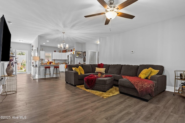 living area featuring recessed lighting, baseboards, dark wood finished floors, and ceiling fan with notable chandelier