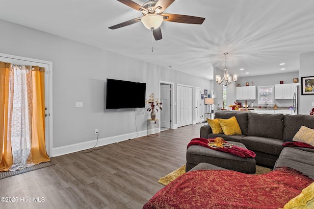 living room with recessed lighting, baseboards, dark wood-style floors, and ceiling fan with notable chandelier
