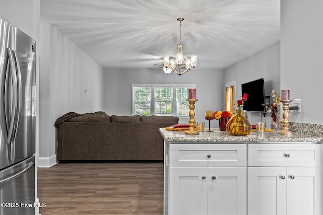 kitchen with a chandelier, open floor plan, white cabinetry, and freestanding refrigerator