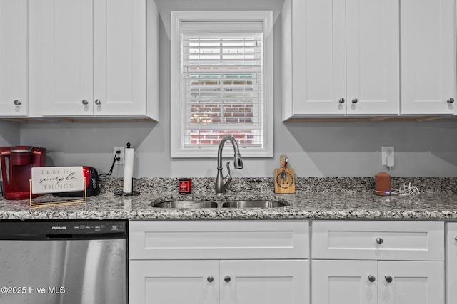 kitchen featuring light stone counters, a sink, white cabinetry, and stainless steel dishwasher