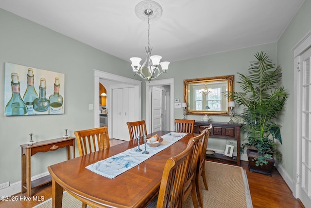 dining room featuring baseboards, wood finished floors, and a chandelier