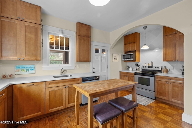 kitchen with brown cabinets, appliances with stainless steel finishes, and a sink