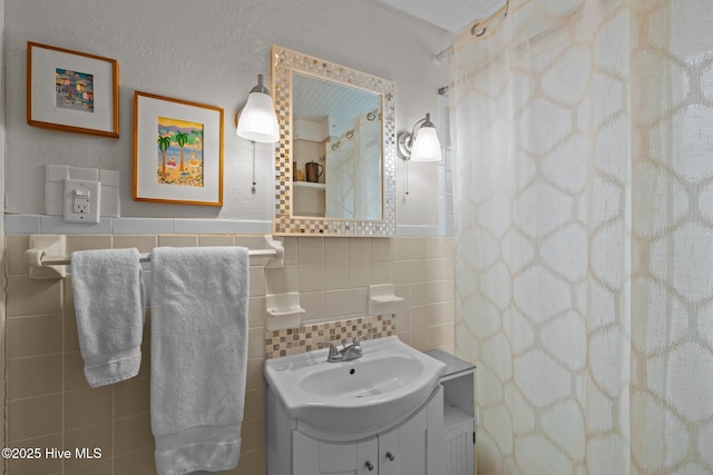 full bathroom featuring vanity, tile walls, and a shower with curtain