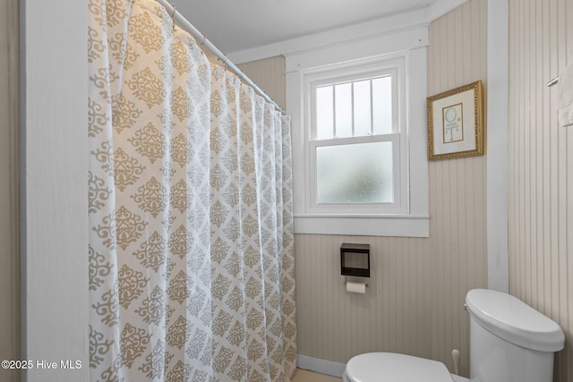 full bathroom featuring toilet, a shower with shower curtain, and baseboards