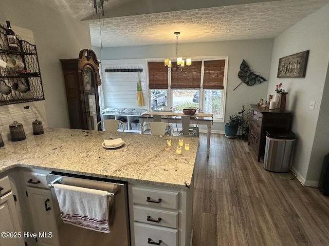 kitchen with baseboards, white cabinets, light stone counters, dark wood-style flooring, and an inviting chandelier