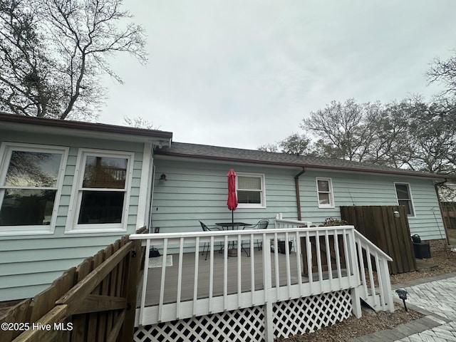 rear view of property featuring fence and a wooden deck