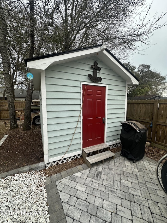 view of outdoor structure with an outbuilding and fence