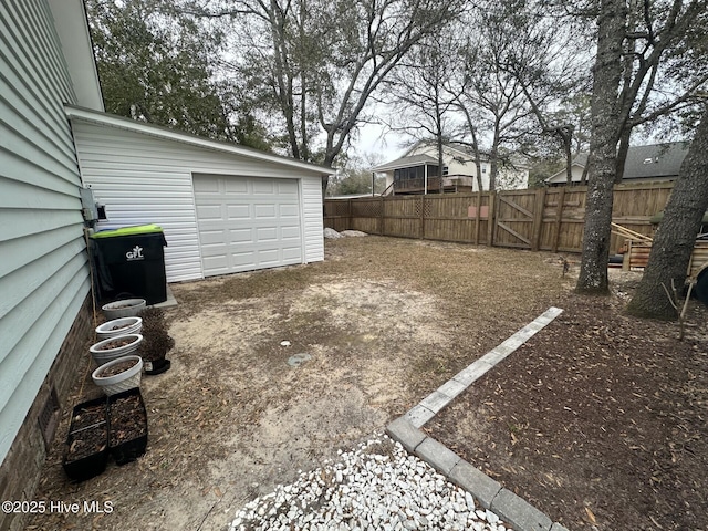 view of yard featuring an outbuilding, concrete driveway, and fence