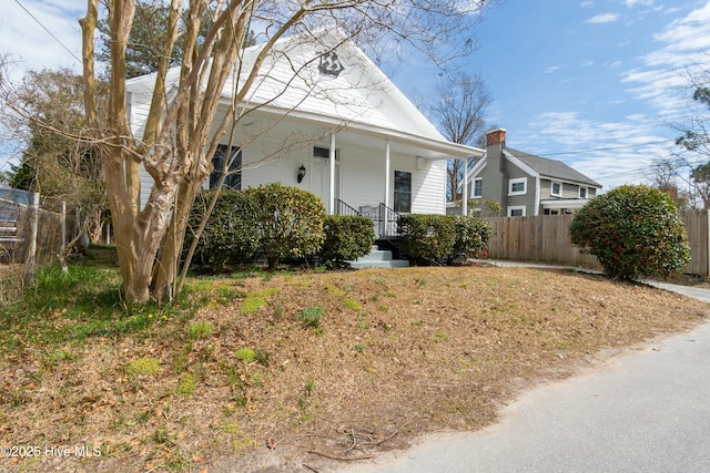 view of front facade featuring covered porch and fence