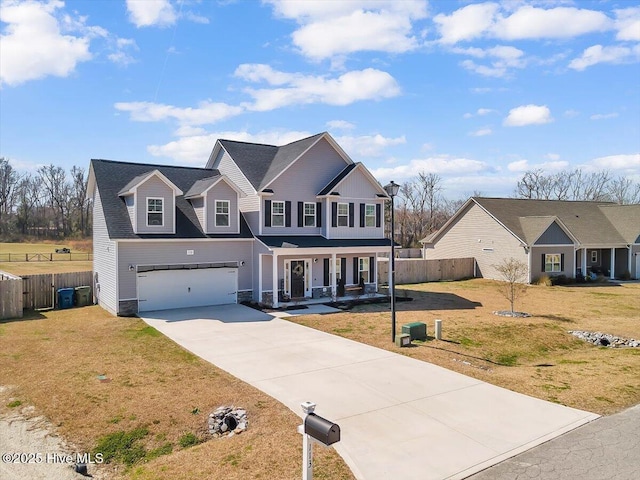 view of front facade with a porch, fence, a garage, and driveway