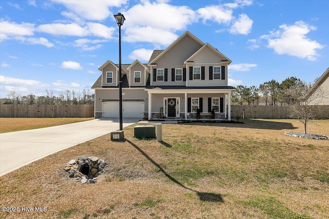 view of front facade featuring driveway, fence, covered porch, a front yard, and a garage