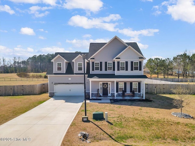 view of front of home featuring concrete driveway, fence, covered porch, and a front lawn