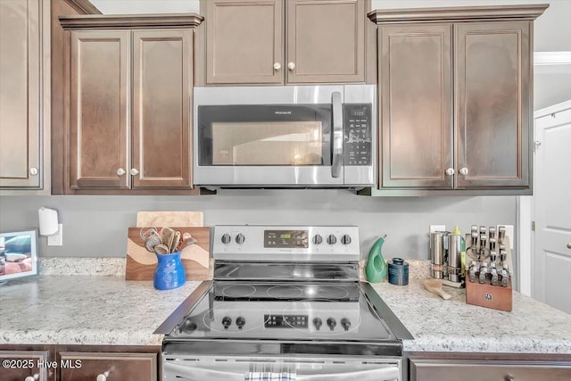 kitchen featuring light stone counters and stainless steel appliances