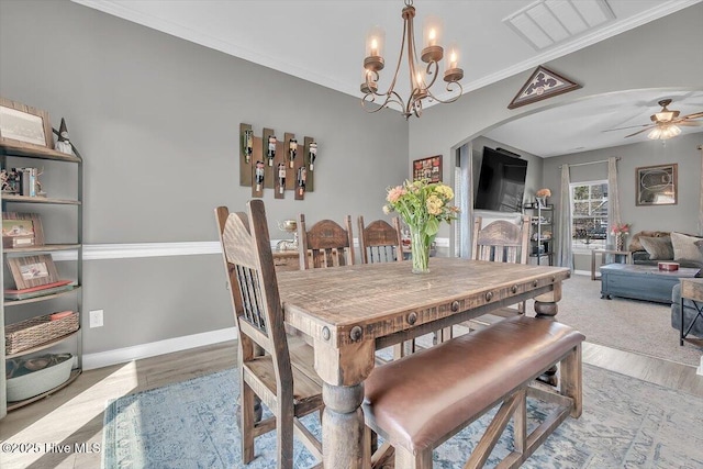 dining room with arched walkways, visible vents, crown molding, and baseboards