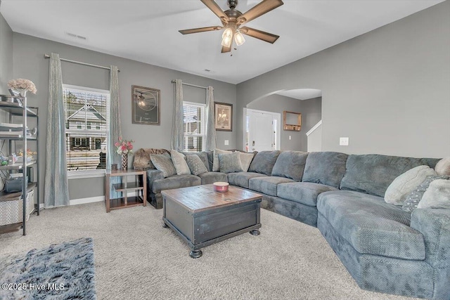 living room featuring visible vents, carpet floors, plenty of natural light, and arched walkways