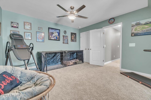 living area featuring baseboards, carpet floors, and a ceiling fan