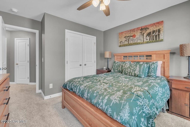 bedroom featuring a closet, light colored carpet, baseboards, and ceiling fan