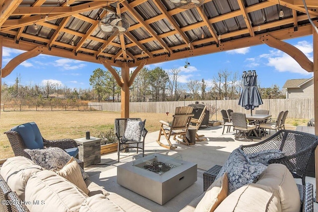 view of patio / terrace with a gazebo, outdoor dining space, an outdoor living space with a fire pit, and a fenced backyard