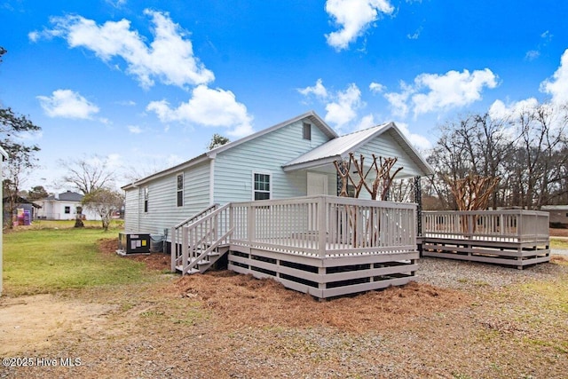 rear view of house with a lawn, central AC, and a deck