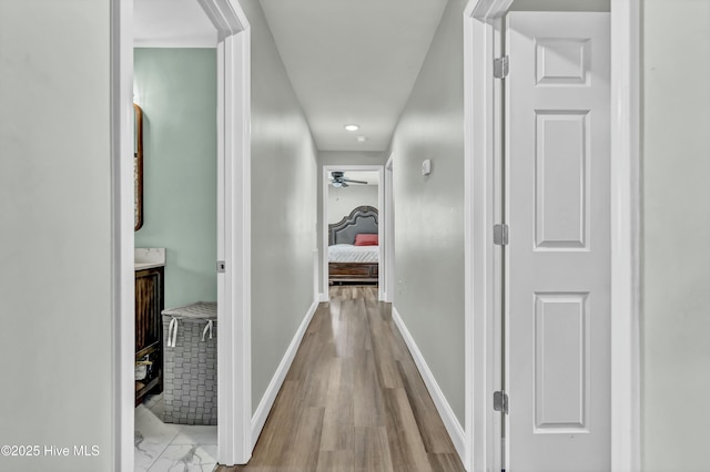 hallway with wood finished floors and baseboards