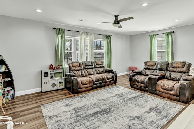 living room featuring a wealth of natural light, baseboards, wood finished floors, and recessed lighting