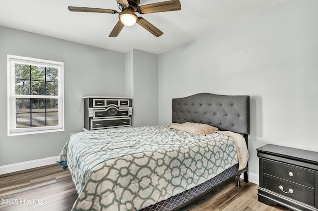 bedroom with a ceiling fan, baseboards, and wood finished floors