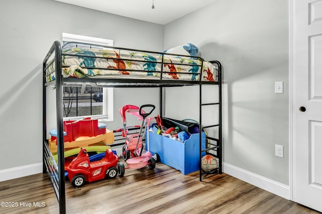 bedroom featuring baseboards and wood finished floors