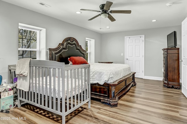 bedroom featuring wood finished floors, visible vents, baseboards, recessed lighting, and ceiling fan