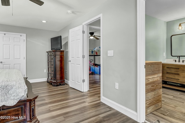 bedroom with a sink, baseboards, wood finished floors, and recessed lighting