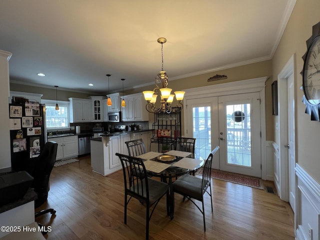 6725 Hemlock Ct, Sims, NC 27880 - dining room with dark wood finished floors, a wainscoted wall, a decorative wall, crown molding, and a chandelier