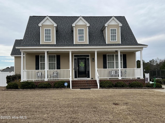 view of front of home featuring roof with shingles, a porch, and a front lawn