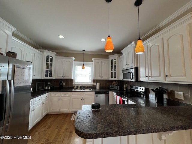 6725 Hemlock Ct, Sims, NC 27880 - kitchen with a peninsula, a sink, dark countertops, crown molding, and appliances with stainless steel finishes