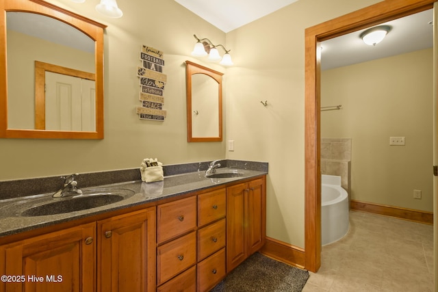 full bath featuring a sink, baseboards, a bath, and double vanity