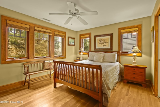 bedroom featuring visible vents, baseboards, light wood-style floors, and ceiling fan