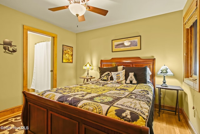 bedroom with a ceiling fan, baseboards, and wood finished floors