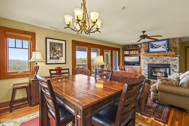 dining area featuring a wealth of natural light, a fireplace, and light wood-style floors