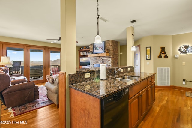 kitchen featuring black dishwasher, visible vents, open floor plan, and a sink