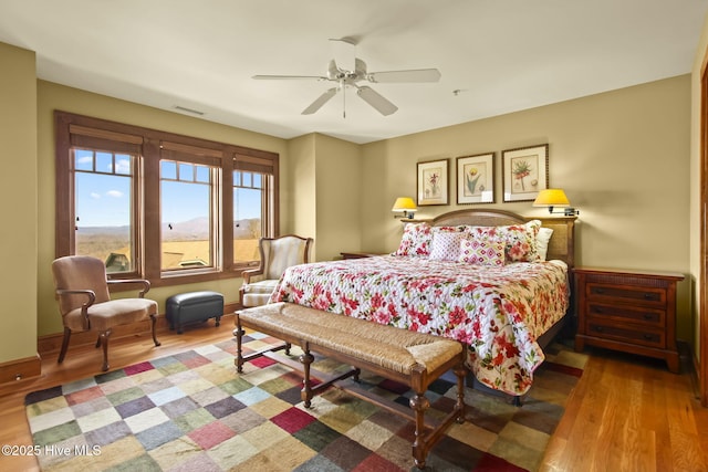 bedroom with visible vents, ceiling fan, baseboards, and wood finished floors