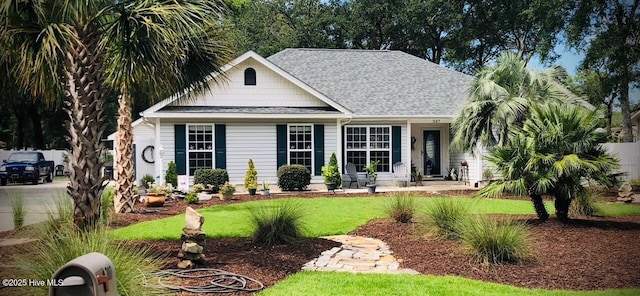 view of front of house featuring a front yard and a shingled roof