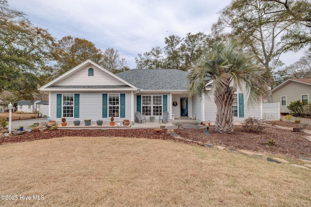 single story home with a front lawn, fence, and a shingled roof