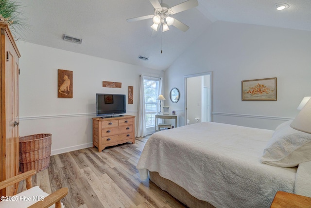 bedroom featuring a ceiling fan, lofted ceiling, light wood-style floors, and visible vents