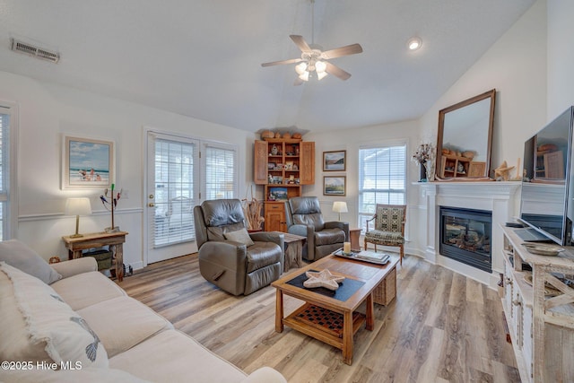 living room featuring visible vents, plenty of natural light, a ceiling fan, and vaulted ceiling